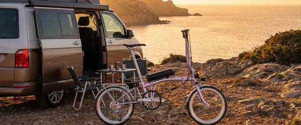 Kenotu K10 folding electric bike next to a camper van during European summer travel by the coast